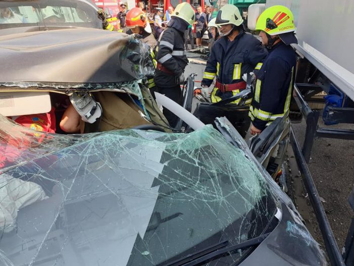 Autoturism nimerit sub un TIR, victime scăpate miraculos cu viață. Descarcerare făcută de pompieri (galerie foto)