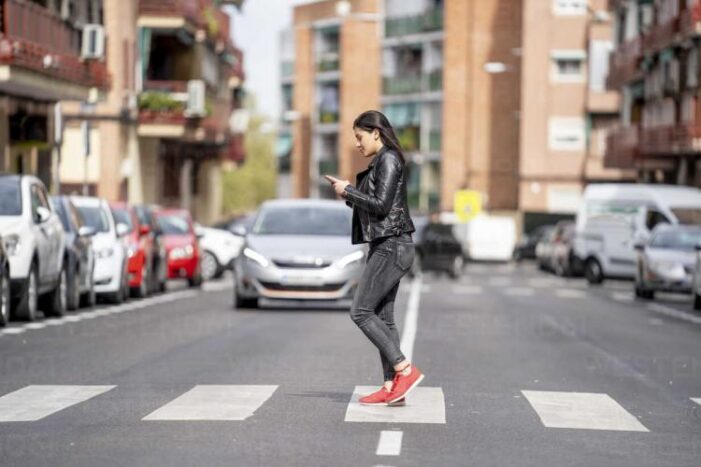 Pietonii care se uită în telefon când traversează strada ar putea fi amendați